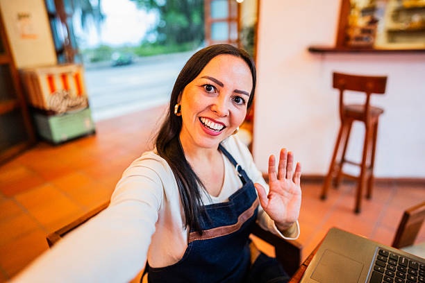 istock Waitress making video call in a coffee shop - camera point of view 2209777775