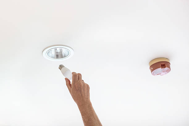 istock mature man replacing led light bulb on ceiling in apartment 2209778865