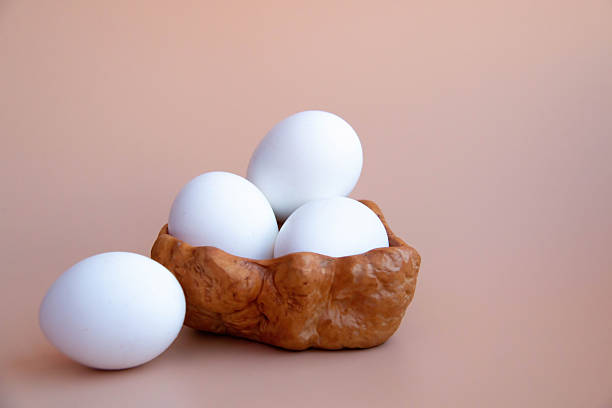 istock Minimalist Still Life White Eggs in Natural Wooden Bowl Rustic Style Delicate Beige background. Natural Tones Perfect for Kitchen Decor Culinary Themes Diet Proteins Breakfast articles Easter themes 2209779617