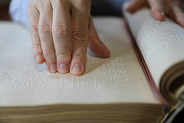 istock Blind Woman Over 50 Reading Braille Book 2209784210