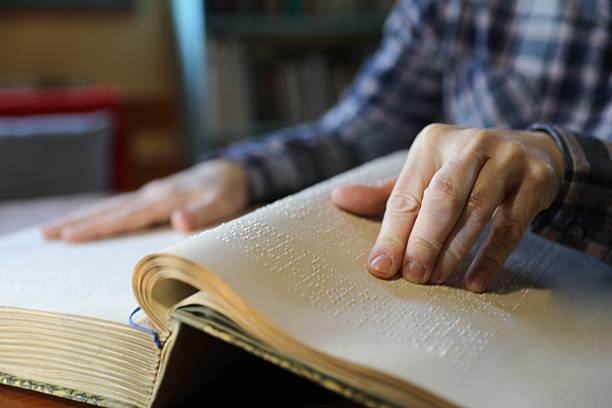 istock Blind Woman Over 50 Reading Braille Book 2209784308