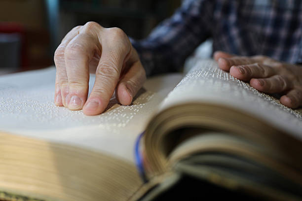 istock Blind Woman Over 50 Reading Braille Book 2209784326