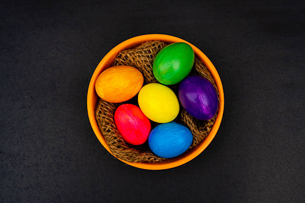 Colorful Easter Eggs in Orange Bowl on Black Background