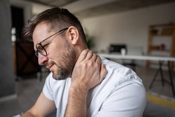 istock Man suffering from neck pain at home office 2209786018