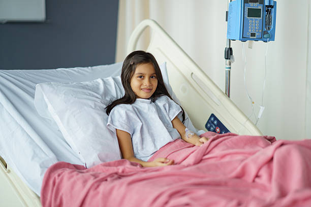 istock Young Girl Smiling While Resting in a Comfortable Hospital Bed 2209787400