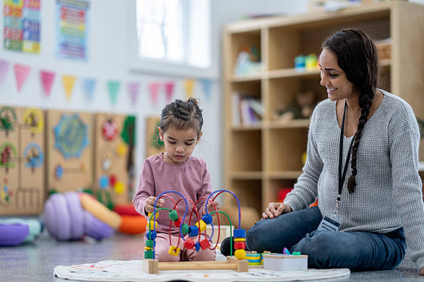 istock Teacher and Child Engaged in Educational Activity in Classroom Setting 2209788383