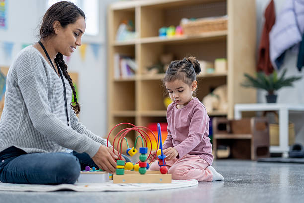 istock Teacher and Child Engaged in Educational Activity in Classroom Setting 2209788385