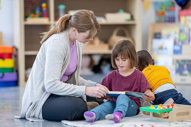 istock Teacher Reading to Young Child in a Bright Learning Environment 2209788984