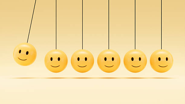 A digitally generated image featuring a Newton’s Cradle where the spheres are replaced with smiley face emojis, symbolizing positivity, collaboration, and the emotional dynamics of teamwork and leadership. This cheerful and engaging design highlights how positive energy and communication drive group momentum, making it ideal for business, motivation, and workplace culture themes.