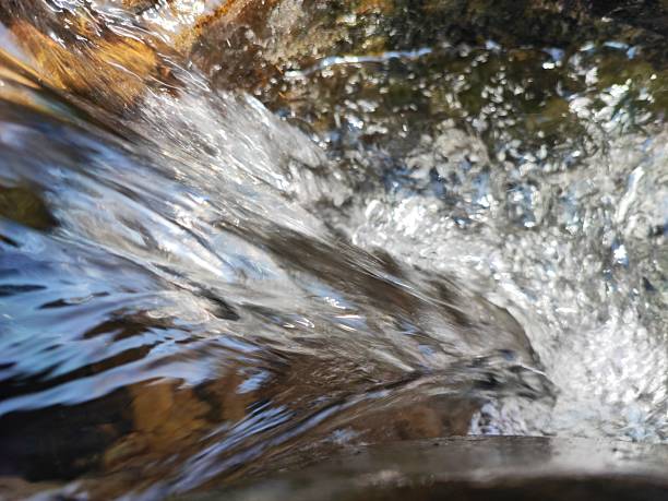 istock Flowing water with blue and gold colours and bubbles 2209791575