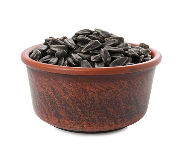 istock Sunflower seeds in bowl isolated on white 2209791722