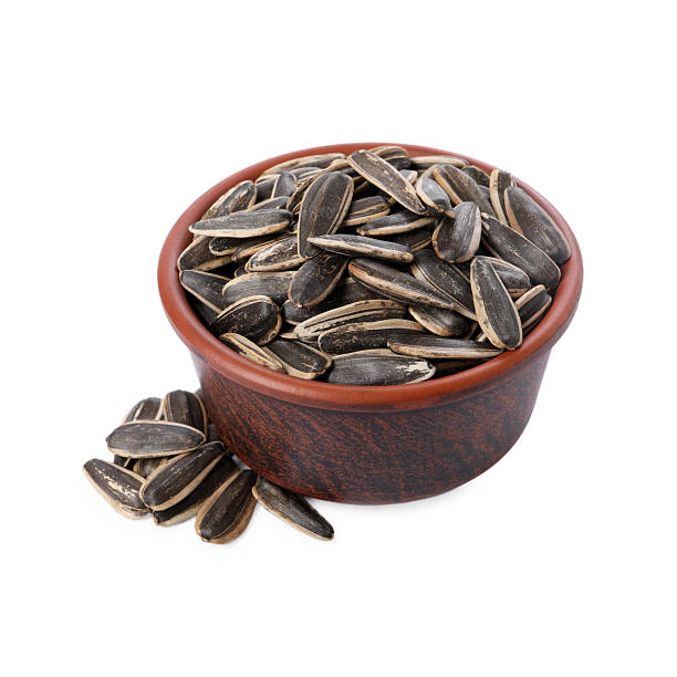 istock Sunflower seeds in bowl isolated on white 2209791761