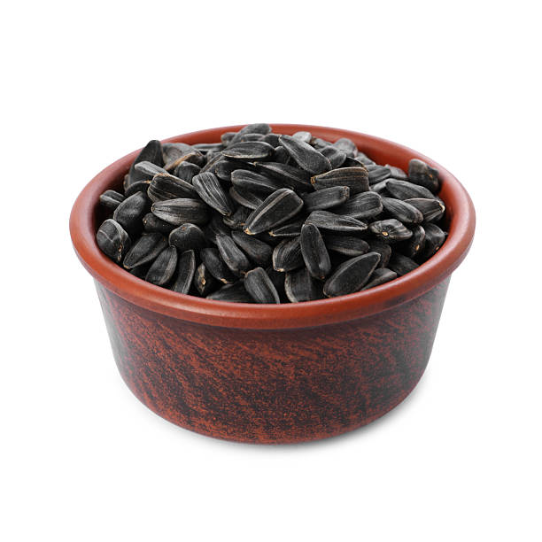 istock Sunflower seeds in bowl isolated on white 2209791811