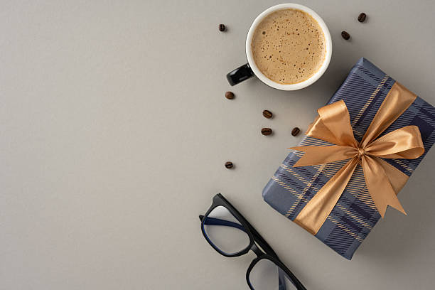 istock Delightful coffee cup alongside a wrapped gift and glasses on neutral surface 2209795505