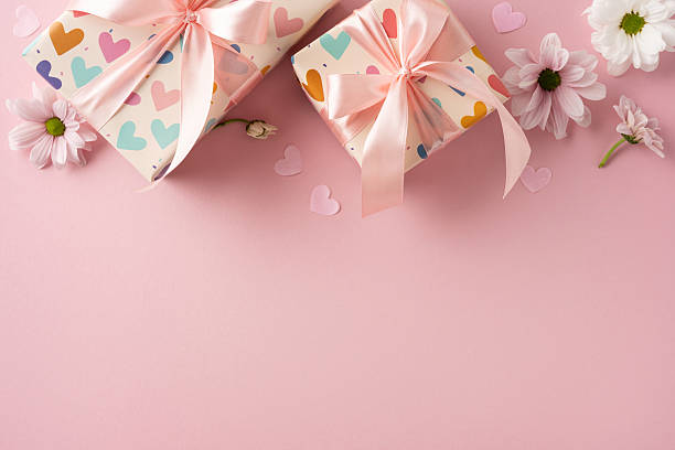 istock Colorful heart-patterned gift boxes with pink ribbons surrounded by daisies on a soft pastel surface 2209795523