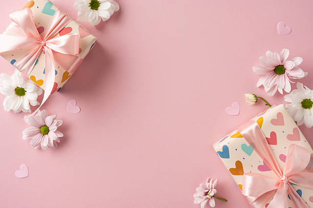 istock Gift boxes with ribbons and daisies on a pink backdrop evoke celebration and love 2209795525