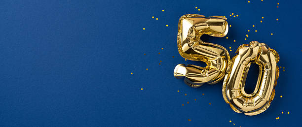 Gold number balloons shaped as fifty, symbolizing celebration, displayed with confetti on blue
