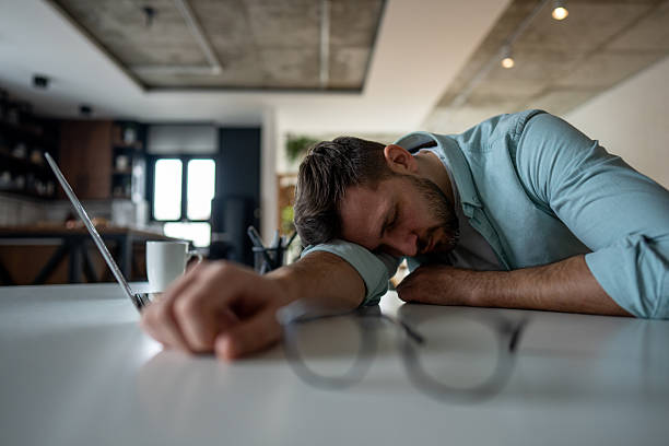istock Exhausted freelancer sleeping on desk after working on laptop 2209795623