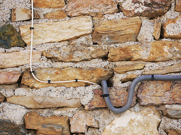 old historical brick wall equiped with new calbes for internet and electricity