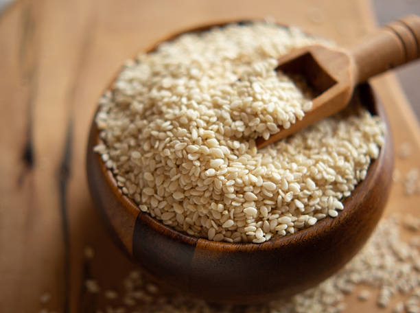 istock Bowl with sesame seeds and wooden spatula on rustic background 2209797438