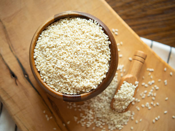 istock Bowl with sesame seeds and wooden spatula on rustic background 2209797444