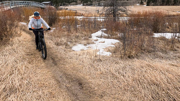 istock Mature woman e-bikes along pathway in mountains 2209797807