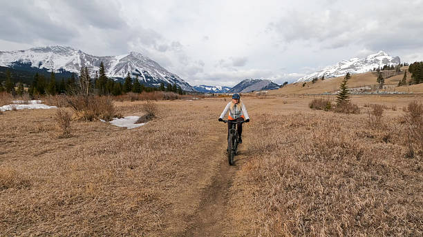 istock Mature woman e-bikes along pathway in mountains 2209798569