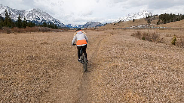 istock Mature woman e-bikes along pathway in mountains 2209798655
