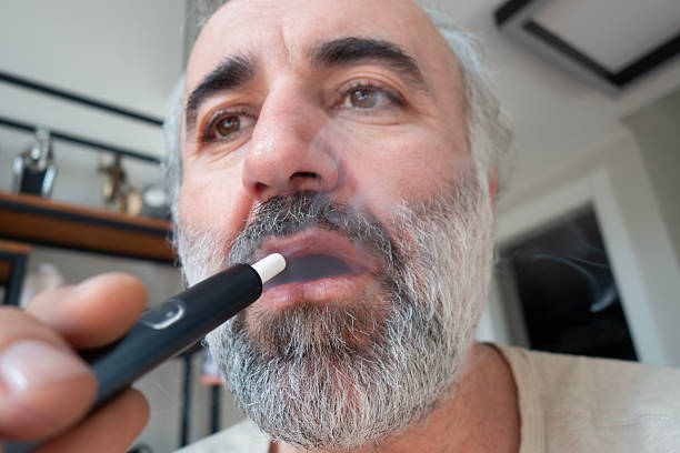 istock Close up of a man vaping with electronic cigarette. 2209798787