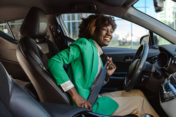 istock Woman fastening seatbelt in a car while smiling confidently 2209802047