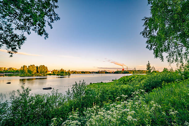 Beautiful landscape and cityscape of city of Oulu, with factory chimney in the background taken under midnight sun during long summer day