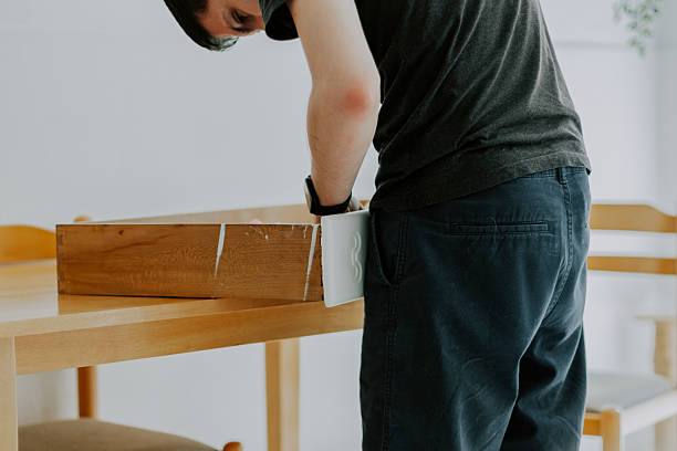 istock A young man repairs a retro handle on a drawer. 2209804063