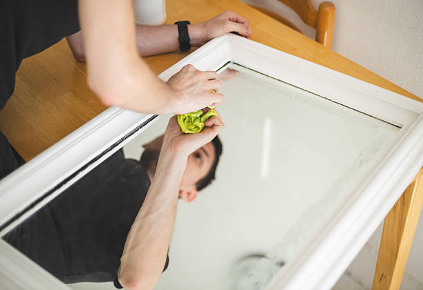 istock A young man washes a mirror after painting at home. 2209805195