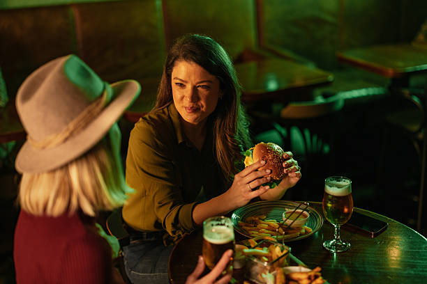 istock Friends enjoying burgers and beers in a pub 2209806607