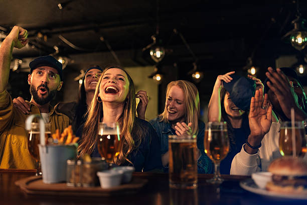 istock Excited friends cheering and laughing while watching sports in a pub 2209806664