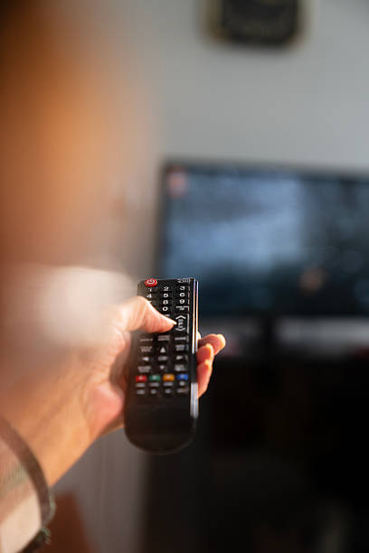 istock A person holds a TV remote control 2209811354