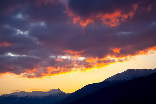 A stunning evening sky with glowing orange and golden clouds against a soft blue background. The illuminated edges of the clouds add depth and drama to the scenery.