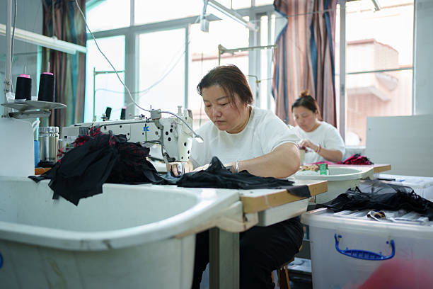 istock Female sewing worker in factory 2209835180