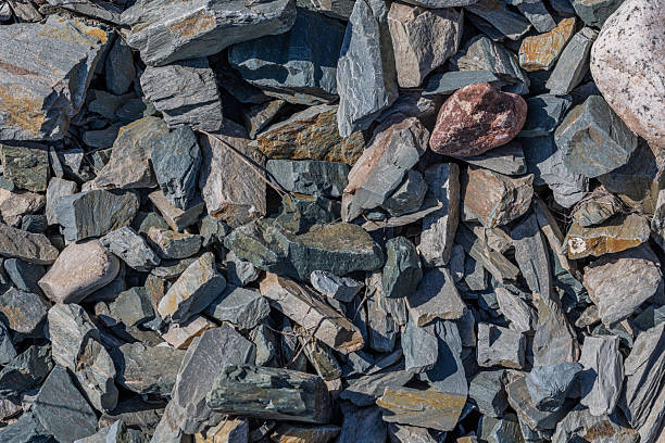 Pile of various rough stones and rock fragments under bright sunlight.