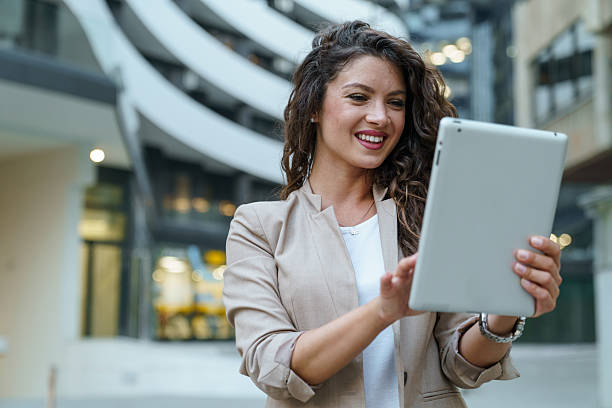 istock Young Business Woman Using Digital Tablet In Modern Office Building With Curved Architecture 2209842410