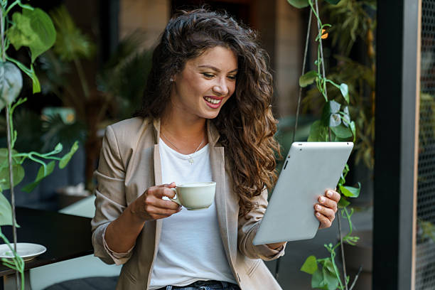 istock Smiling Young Caucasian Woman Using Tablet While Enjoying Coffee in Eco-Friendly Caf? 2209843025