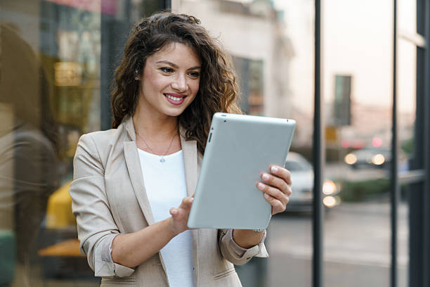 istock Confident Young Businesswoman Using Digital Tablet Outdoors in Bright Urban Setting 2209843061