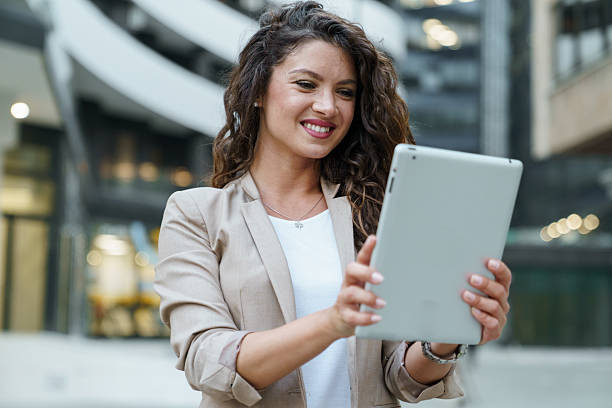 istock Confident Caucasian Businesswoman Smiling While Using a Tablet in a Modern Urban Setting 2209843071