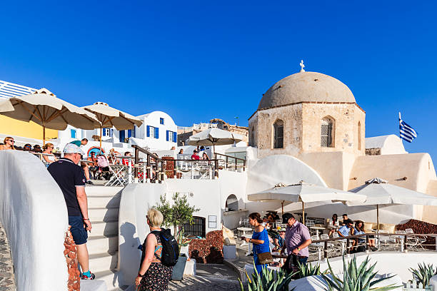 Oia,Santorini,Greece-September 5th 2013:Unknown tourists mainly caucasian enjoying the quaint cave houses in Oia- a coastal town on the northwestern tip of Santorini, a Greek Aegean island.