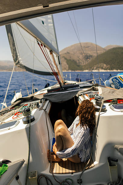 istock Woman sitting in cockpit while sailing and enjoying 2209848404