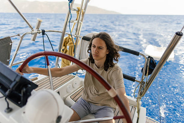 istock Teenage boy steering sailboat while sailing on wind power 2209848406