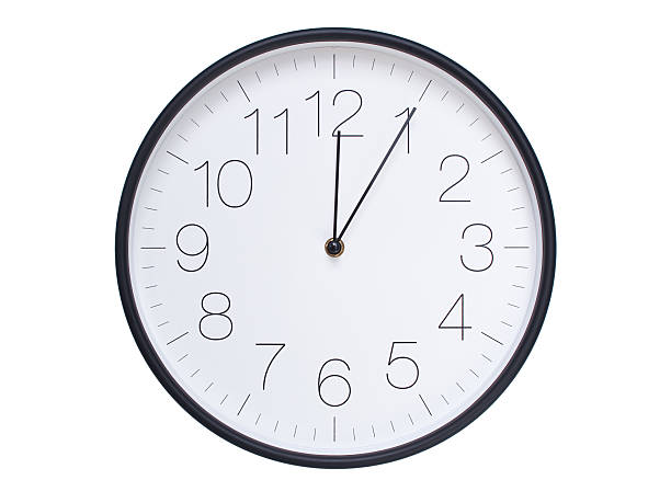 istock Simple wall clock with black frame and white face displaying 00:05 or 12:05. Ideal for time, schedule, and punctuality themes. 2209849841