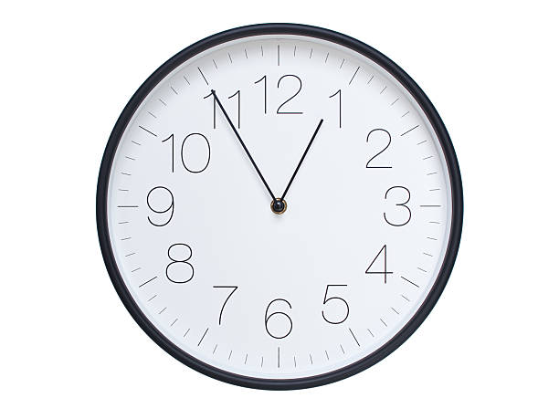 Minimalist Round Wall Clock Showing 00:55 or 12:55. Thin Black Numerals on White Wood Background.