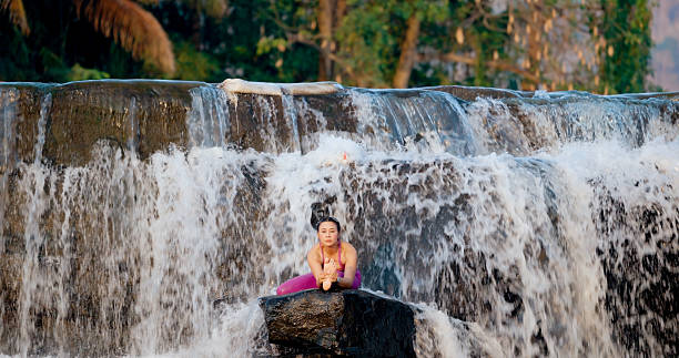 istock Yoga woman before waterfall. 2209849993