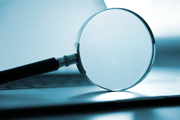 Laptop computer with magnifying glass as a symbol for searching for information on the Internet